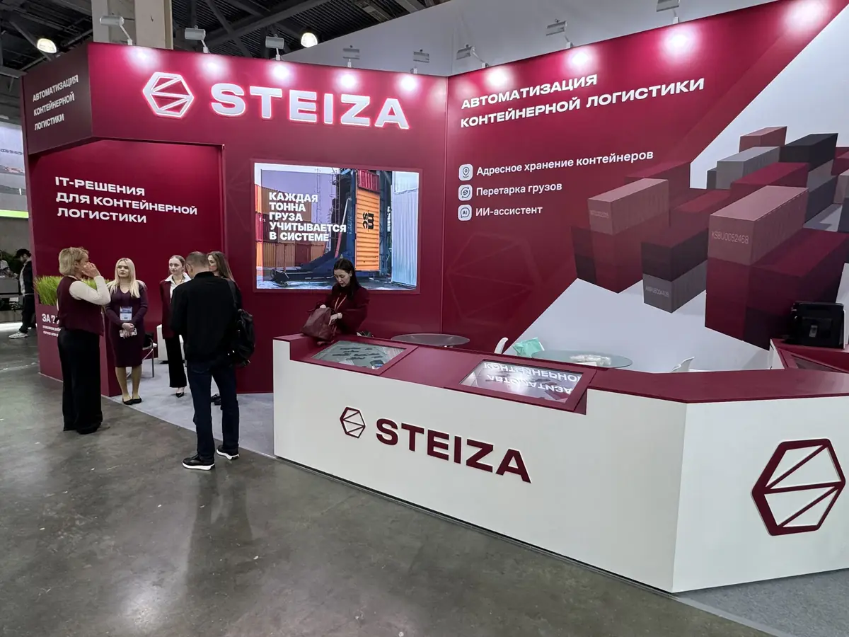Стенд Steiza целиком: малиновые стены со светящимся логотипом, надписи «IT-решения для контейнерной логистики» и «Автоматизация контейнерной логистики», экран со слоганом, список модулей на стене и белая стойка с сенсорными экранами